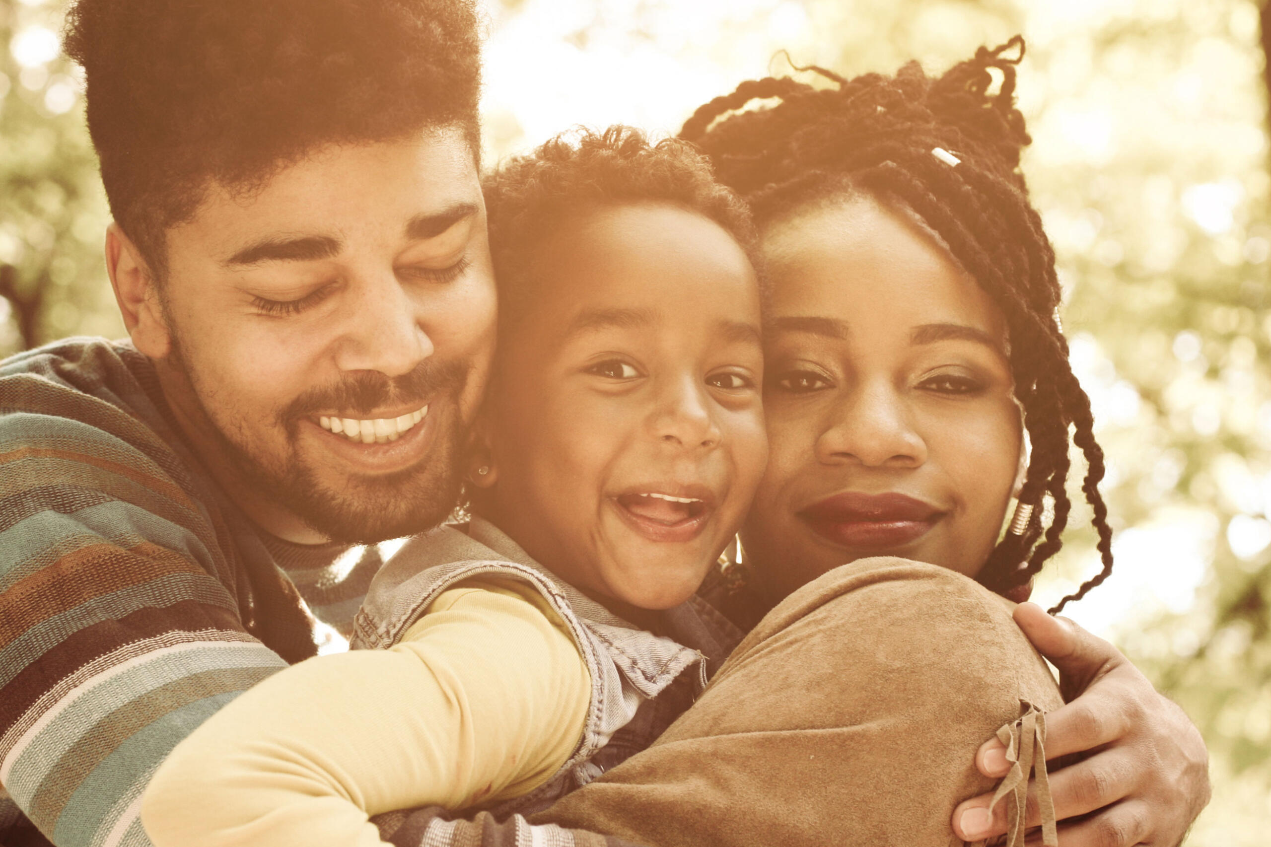 Mother and father hugging their smiling child